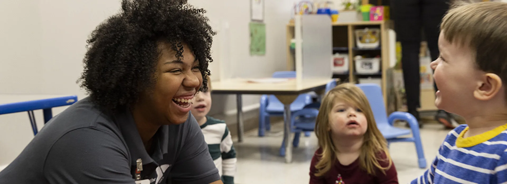 smiling teacher and toddler